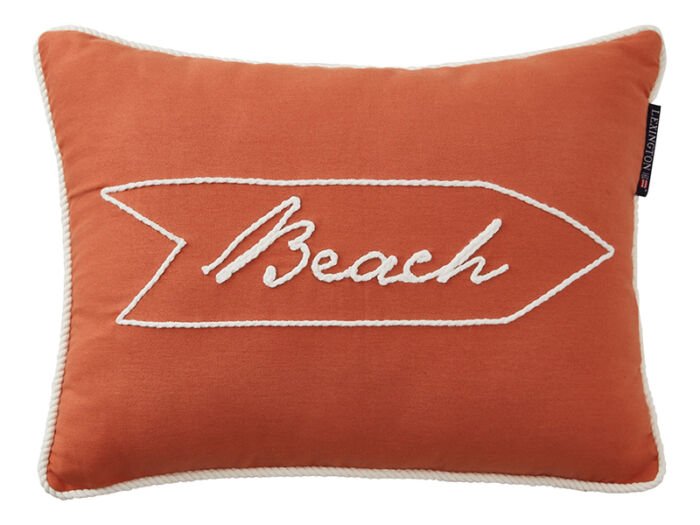 Terrakottafarbenes Kissen mit aufgesticktem BEACH in Wegweiseroptik