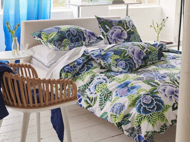 Nachtblaue Bettwäsche mit floralem Muster auf weißem Bett